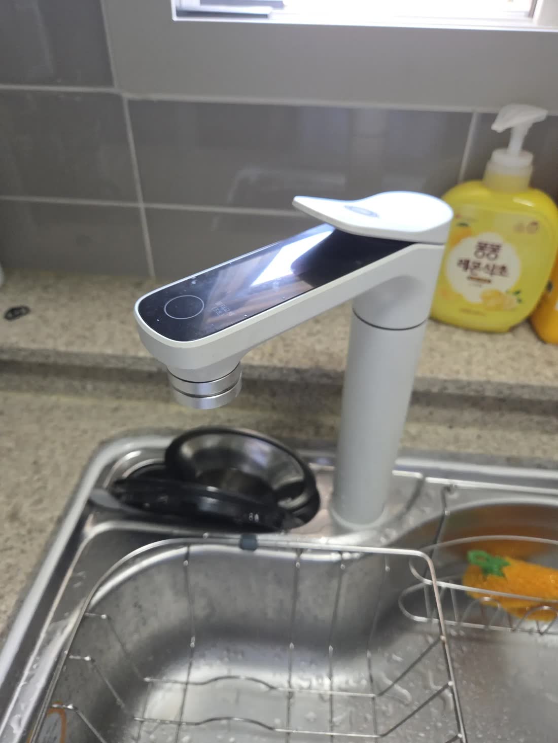 가정집 주방 타일 벽 앞에 설치한 정수기
